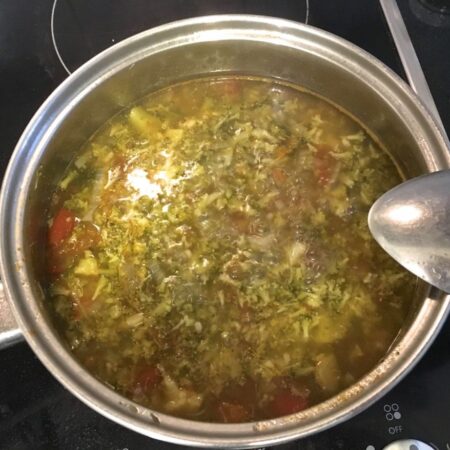 Broccoli and tomato soup in a saucepan, cooking on the stove