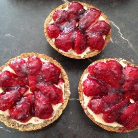 3 little strawberry tarts on a kitchen bench
