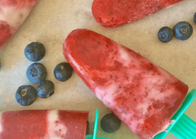 Strawberries and cream popsicles laid on a bench