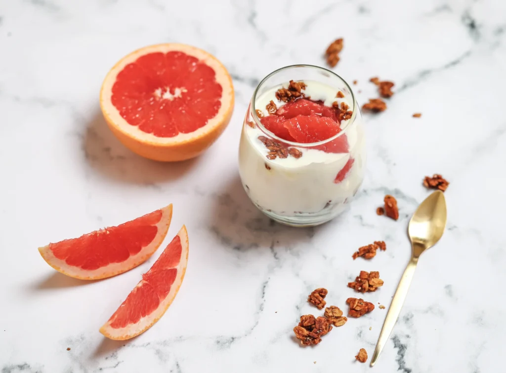 Grapefruit breakfast pot sitting on a bench with a spoon and half a fresh grapefruit 