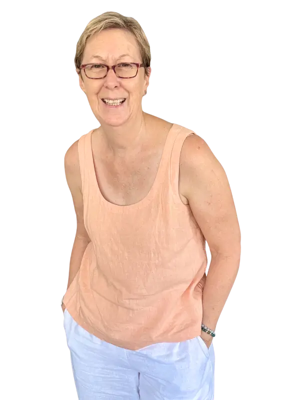 Wendy standing hands in pockets, orange linen top and white trousers